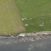 Oblique aerial view centred on the coastal gun battery with the remains of the broch adjacent, taken from the N.