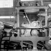 Copy of photograph of paper making machine (no.6), Wet Press Section comprises two presses, the first being the straight through suction type with 'Millspaugh' Suction Roll and the second, a plain reversing press. Both the top granite rollers are carried in roller bearings in spherical housings. The cast-steel levers supporting these rolls are equipped with double acting air cylinders for applying pressure as well as raising clear when changing felts, from the JB&S Machine 161 catalogue, James Bertram and Son Ltd, Leith Walk, Edinburgh, circa 1953. The catalogue describes and illustrates some of the features of the No 161 machine 'recently installed at the well known Mill of Guard Bridge Paper Co Ltd, Fife , Scotland designed with the co-operation of the Mill Staff especially for the economical production of the highest quality papers...'