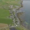 Oblique aerial view centred on the village with the pier adjacent, taken from the W.