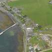 Oblique aerial view centred on the village with the pier adjacent, taken from the SE.