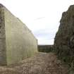 Interior, detail of south rock cut ditch with concrete revetting from the WSW.