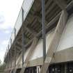 Detailed view of Meadowbank Stadium from the east, showing the exposed concrete structure of the grandstand and concrete panels at concourse level.