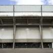 Detailed view of Meadowbank Stadium, Edinburgh, from the south, showing the exposed concrete structure of the grandstand and concrete panels to the concourse level.