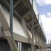 Detailed view of Meadowbank Stadium from the southwest, showing the exposed concrete structure of the grandstand and concrete panels to the concourse level.