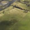 Oblique aerial view centred on the remains of rig and furrow cultivation with the remains of Chapel roaund adjacent, taken from the NW.