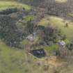 Oblique aerial view centred on the country house with the home farm and walled garden adjacent, taken from the W.