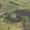 Oblique aerial view centred on the country house with the home farm and walled garden adjacent, taken from the SSE.