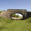 View from SSW showing Cowbraehill road bridge arch, span and abutments across the former railway track