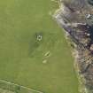 Oblique aerial view centred on the remains of the possible broch and buildings at North Howe, taken from the WNW.