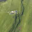 Oblique aerial view centred on the burial ground at Scockness with Scockness Farm adjacent, taken from the S.