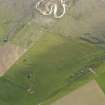 Oblique aerial view centred on the ruins of the farmstead and field boundaries at Hill of Borwick with the remains of a firing range adjacent, taken from the NE.