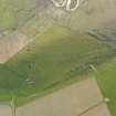 Oblique aerial view centred on the ruins of the farmstead and the field boundaries at Hill of Borwick with the remains of a firing range adjacent, taken from the NE.