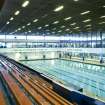 Interior view of Royal Commonwealth Pool, Edinburgh. Elevated oblique view from spectator seating bank, looking N along SW side of main pool hall.