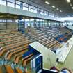 Interior view of Royal Commonwealth Pool, Edinburgh. Elevated view from spectator seating bank, looking NW along spectator seating on SW side of main pool hall.
