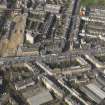 Oblique aerial view centred on Leith Walk with the site of the former tram and bus depot adjacent, taken from the SE.