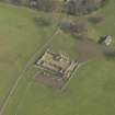 Oblique aerial view centred on the remains of the stable block with the garden house adjacent, taken from the W.