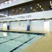 Interior view of Royal Commonwealth Pool, Edinburgh. View of NW end of competition pool and main pool hall, including entrances to changing areas and viewing windows from entrance concourse.