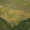 Oblique aerial view centred on the cropmarks of the barrow and field boundaries, taken from the WSW.