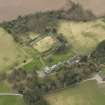 Oblique aerial view centred on the country house with the stable block and walled garden adjacent, taken from the NNE.
