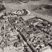 Oblique aerial view of the Canongate area, Edinburgh, c1951 including Holyrood Palace, the Meadow Flat Gas Holders (now the site of Dynamic Earth) and Holyrood Brewery (now the site of the Scottish Parliament).