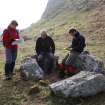 RCAHMS staff (Angela Gannon, Ian Parker and George Geddes) discuss the burial chamber at Dunagoil.
