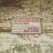 Detail of a painted sign located in Bishopton Royal Ordnance Factory, warning of the hazardous working conditions.