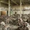 Interior. General view of main hall in phosphorus charging house showing part of the conveyor belt system and the collapsed brick ovens..