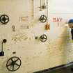 Interior. View in entrance hall, viewing port for bay 1 in propellant charge building with RCAHMS surveyor David Easton.