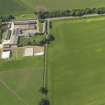 Oblique aerial view of the cropmarks of the enclosure, pits and pit alignment and Saltoun Home Farm, taken from the ENE.