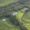 Oblique aerial view centred on the country house with the garage adjacent, taken from the NE.