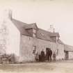 View of building, possibly in Brora, with family group outside. 

