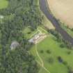 Oblique aerial view centred on the country house with the stable block adjacent , taken from the NW.