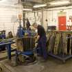 Interior. Cask Rebuild Process. Jamie O' Hare, a cooper for 41 years, building or 'rising' a cask. To his right, the unpacked flat packed ex-bourbon barrel oak staves bought in from the USA. Jamie is placing the oak staves into the end or chime hoop in the pattern: broad, narrow, broad.