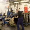 Interior.  Cask Rebuild Process. Jamie O' Hare, a cooper for 41 years, building or 'rising' a cask. The cask is being turned manually for the tightening process to be carried out on the other end of the cask.
