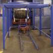 Interior.  Cask Rebuild Process. Croze Machine. A chapped out, trimmed and cut  cask shell with its four temporary truss hoops about to leave the croze machine.