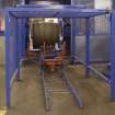 Interior.  Cask Rebuild Process. Croze Machine. A chapped out, trimmed and cut  cask shell with its four temporary truss hoops leaving the croze machine.