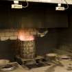 Interior. Cask Rejuvination Process. Charring Area. The gas jet burners. The cask shells to be rejuvinated were placed on movable plates with a circular flange to hold the shell steady. This was slid into place by compressed air and the jet gas burners set alight and the interior of the cask was burnt for about two and a half minutes. Charring carmelises the sugars in the wood and allows the cask to impart colour and flavour into the spirit as it undergoes maturation in the cask..