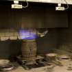 Interior. Cask Rejuvination Process. Charring Area. The gas jet burners. The cask shells to be rejuvinated were placed on movable plates with a circular flange to hold the shell steady. This was slid into place by compressed air and the jet gas burners set alight and the interior of the cask was burnt for about two and a half minutes. Charring carmelises the sugars in the wood and allows the cask to impart colour and flavour into the spirit as it undergoes maturation in the cask..