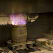 Interior. Cask Rejuvination Process. Charring Area. The gas jet burners. The cask shells to be rejuvinated were placed on movable plates with a circular flange to hold the shell steady. This was slid into place by compressed air and the jet gas burners set alight and the interior of the cask was burnt for about two and a half minutes. Charring carmelises the sugars in the wood and allows the cask to impart colour and flavour into the spirit as it undergoes maturation in the cask..