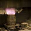 Interior. Cask Rejuvination Process. Charring Area. The gas jet burners. The cask shells to be rejuvinated were placed on movable plates with a circular flange to hold the shell steady. This was slid into place by compressed air and the jet gas burners set alight and the interior of the cask was burnt for about two and a half minutes. Charring carmelises the sugars in the wood and allows the cask to impart colour and flavour into the spirit as it undergoes maturation in the cask..