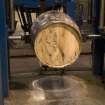 Interior. Cask Rebuilding and Rejuvination Process. Vertical Cask Hoop Driving Machine. First Cask Hoop Drive. The cask has just been turned 180 degrees. One set of end or chime, quarter and bilge hoops have been tightened and the process is to be repeated at the other end of the cask. The cask is still warm from charring (rejuvination) or steaming (rebuild) at this point.