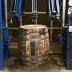 Interior. Cask Rebuilding and Rejuvination Process. Vertical Cask Hoop Driving Machine. Second Cask Hoop Drive. The cask sits vertically in the machine. This machine forces the end, quarter and bilge hoops at both ends of the cask for a second time after the cask has cooled down after steaming or charring. This tightens the cask by forcing the oak staves and chimes together. The cask is now ready for testing.