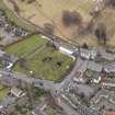 Oblique aerial view centred on the graveyard, taken from the NW.