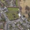Oblique aerial view centred on the graveyard, taken from the W.