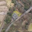 Oblique aerial view centred on the house with the road bridge adjacent, taken from the N.