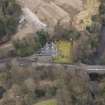 Oblique aerial view centred on the house with the road bridge adjacent, taken from the NNW.