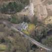 Oblique aerial view centred on the house with the road bridge adjacent, taken from the NW.