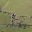Oblique aerial view centred on the remains of the farmstead, taken from the W.