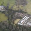 Oblique aerial view centred on the country house with the stables and walled garden adjacent, taken from the N.