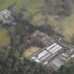 Oblique aerial view centred on the country house with the stables and walled garden adjacent, taken from the N.